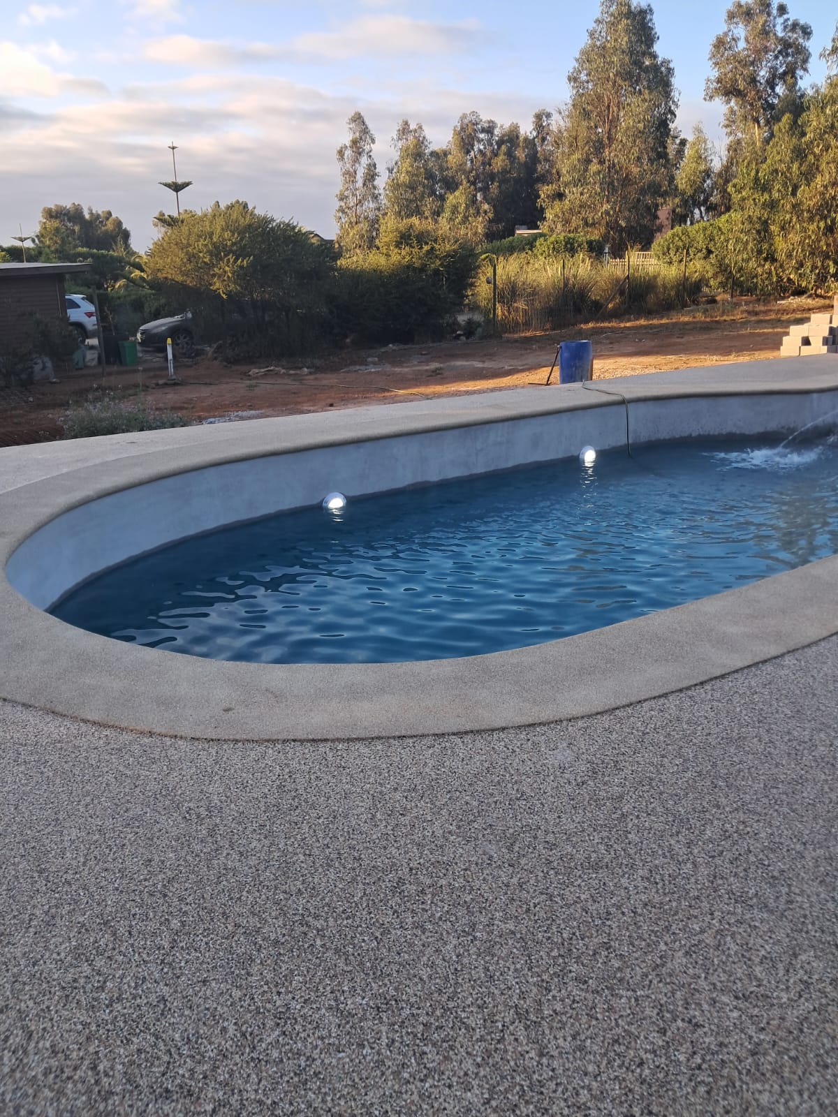 Piscina terminada con bordes de grano y agua cristalina