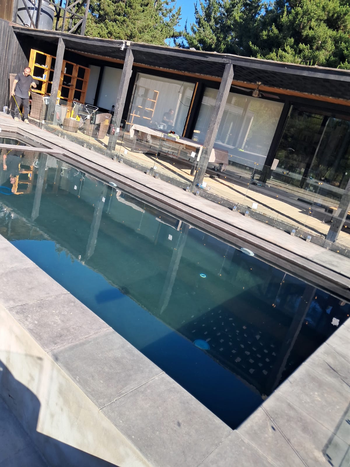 Piscina rectangular moderna bajo terraza metálica