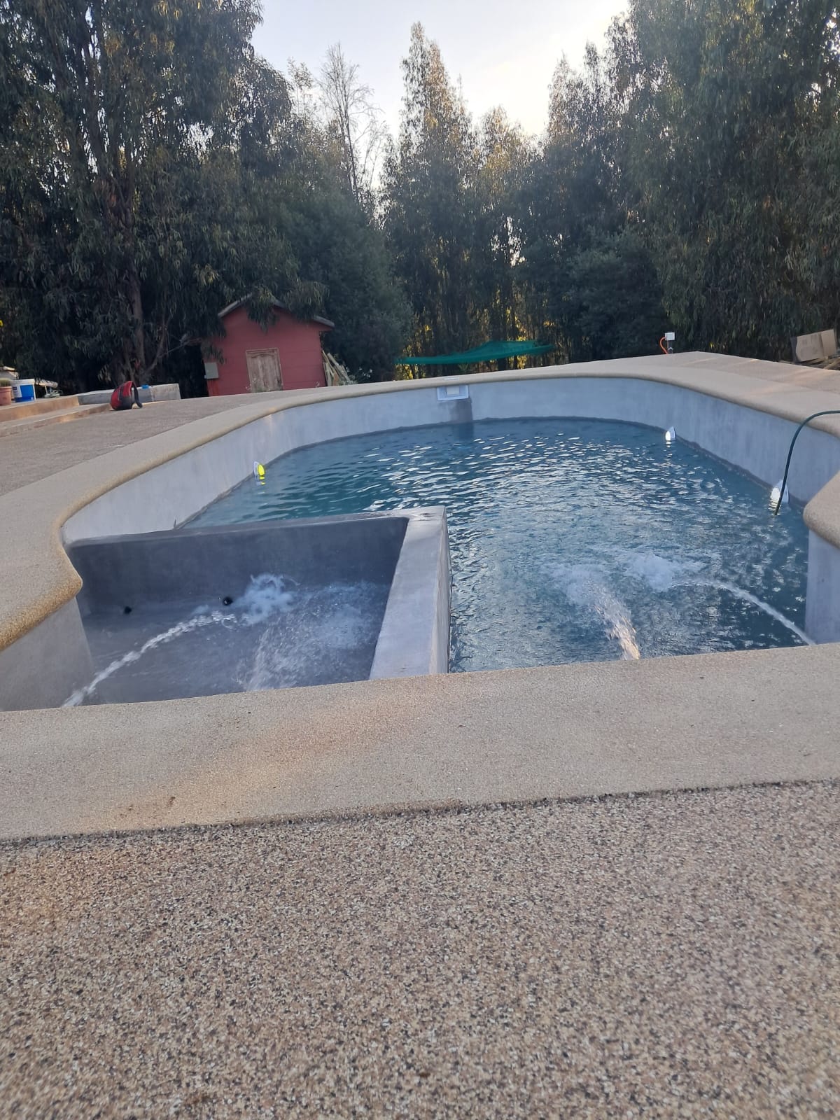 Piscina de concreto con jacuzzi integrado y cascada